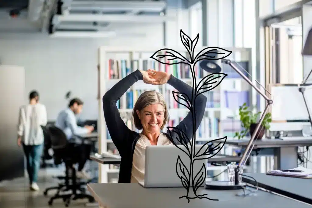 In einem Büro macht eine Frau vor einem Laptop Flexwork-Stretching mit erhobenen Armen. Eine digitale Illustration einer wachsenden Pflanze überlagert das Bild, während im Hintergrund Kollegen beschäftigt sind und eine echte Pflanze auf dem Schreibtisch steht.